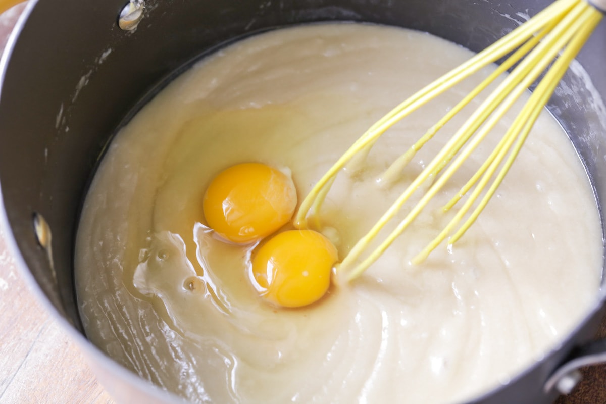 简单的蛋糕食谱-图像bob综合手机客户混合鸡蛋到蛋糕面糊与打蛋器。