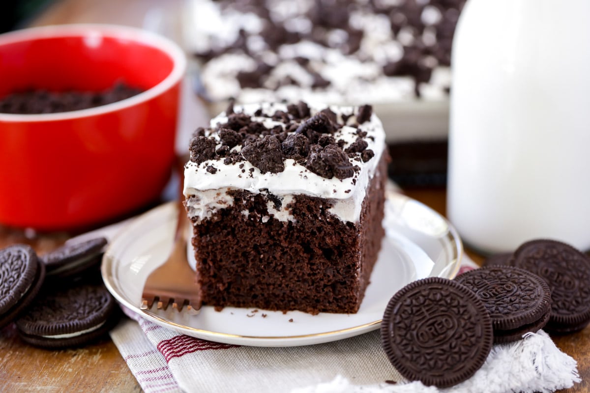 一块巧克力奥利奥蛋糕放在白色盘子上，用叉子叉着吃。