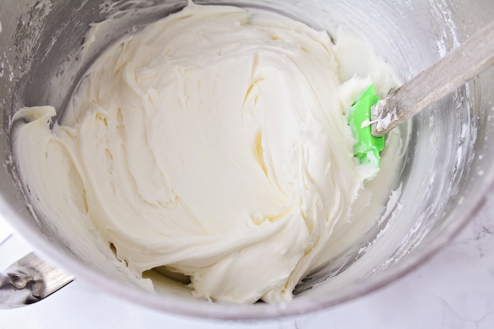 奶油乳酪糖霜放在碗里，浇在胡萝卜蛋糕饼干上。