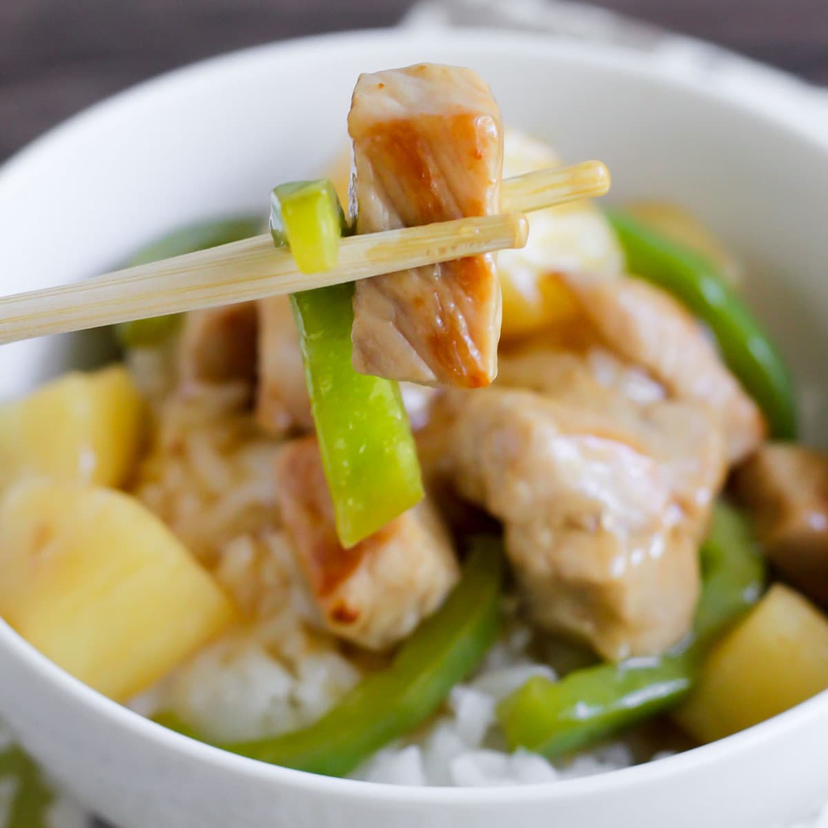 亚洲晚餐食谱-糖醋猪肉放在bob综合手机客户白碗里的白米饭上。
