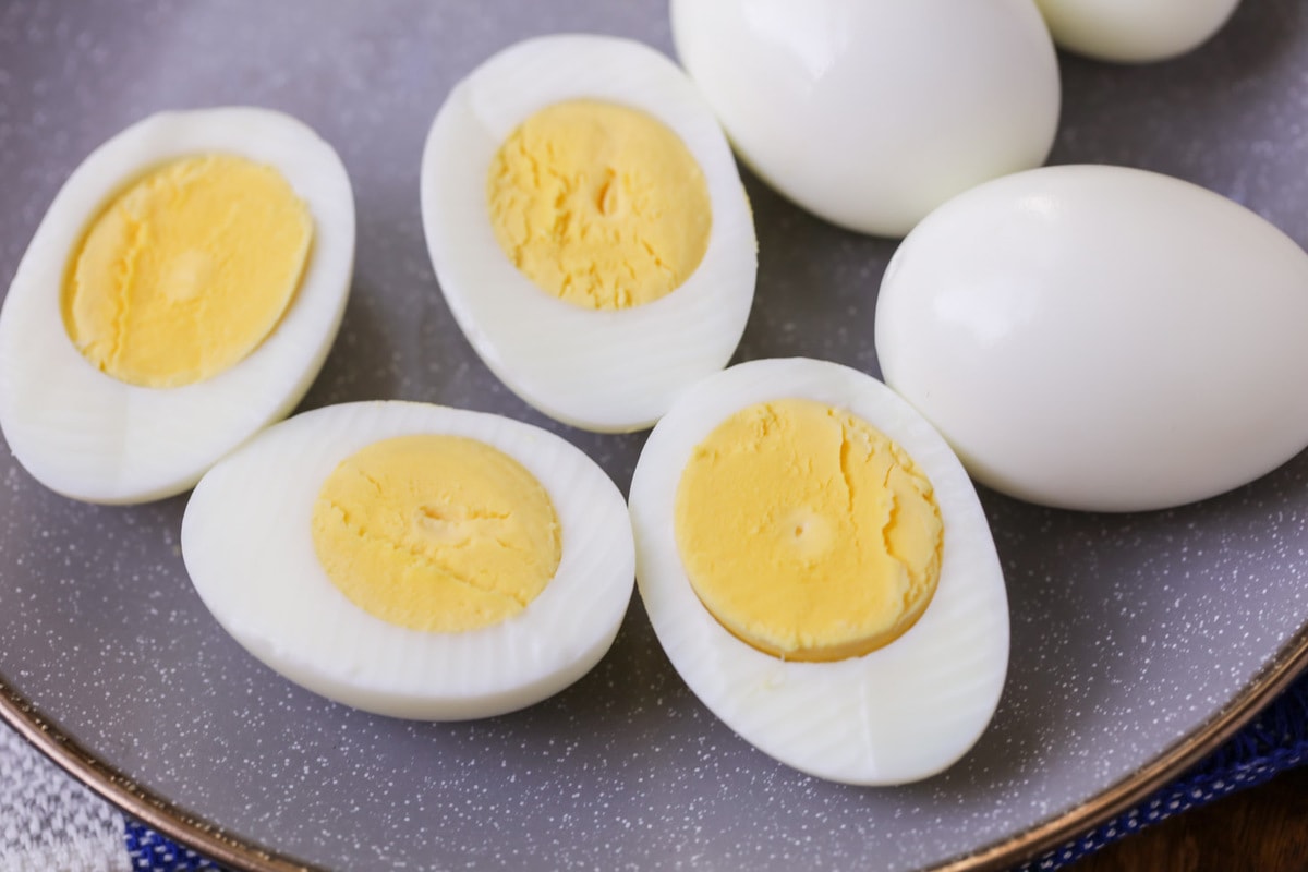 如何煮鸡蛋教程-煮熟的鸡蛋切成两半放在盘子上。