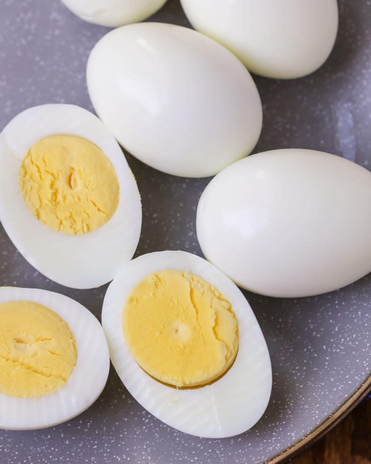 完美的煮鸡蛋，去皮，把一些鸡蛋切成两半放在柜台上。