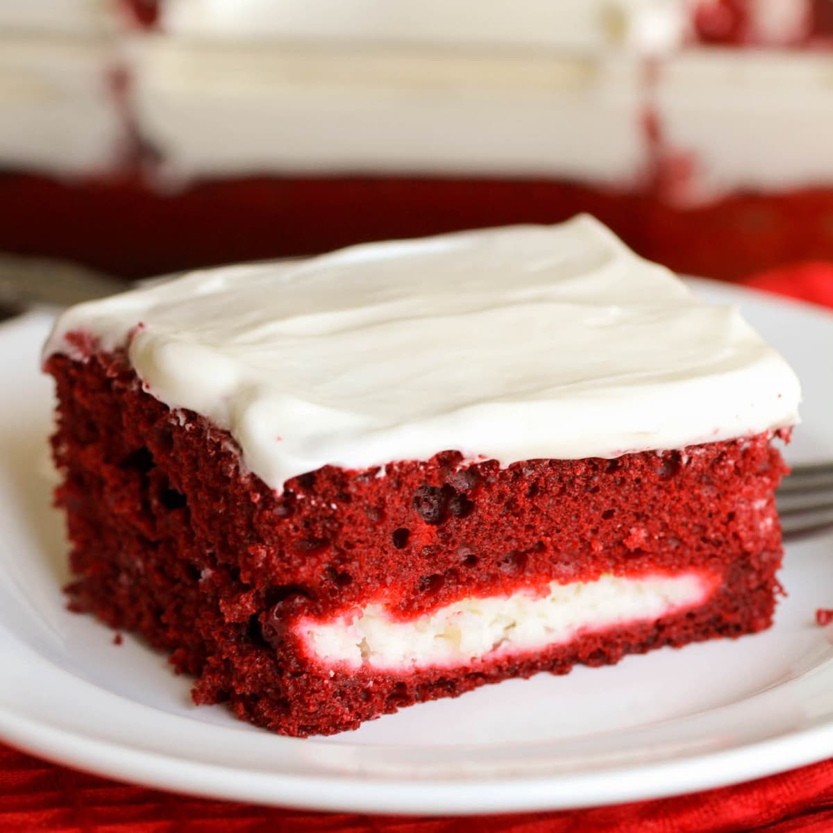 简单的蛋糕食谱-一片bob综合手机客户红丝绒芝士蛋糕在一个白色的盘子。