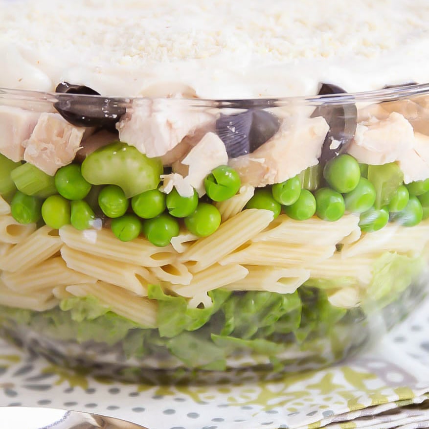 7月4日的配菜——分层的意大利面沙拉在一个玻璃盘子里。