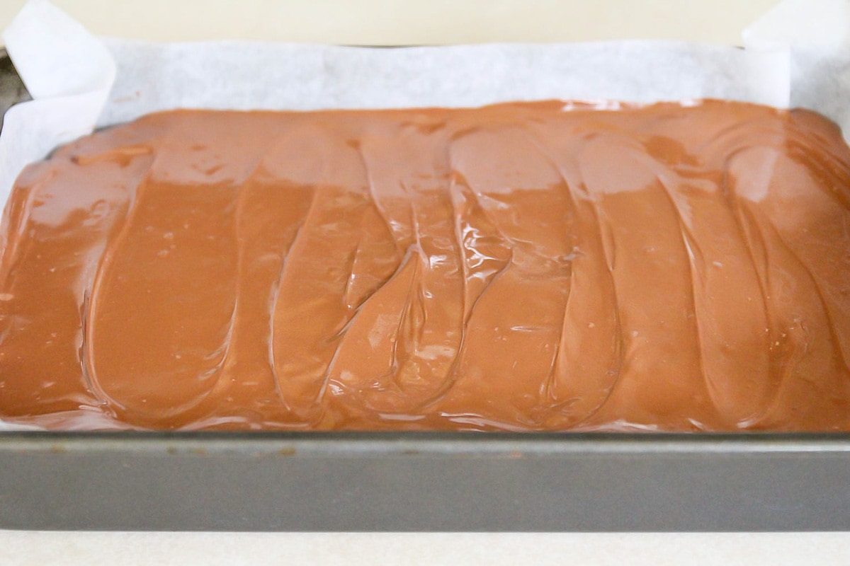 巧克力层上的巧克力焦糖米花在烤盘。