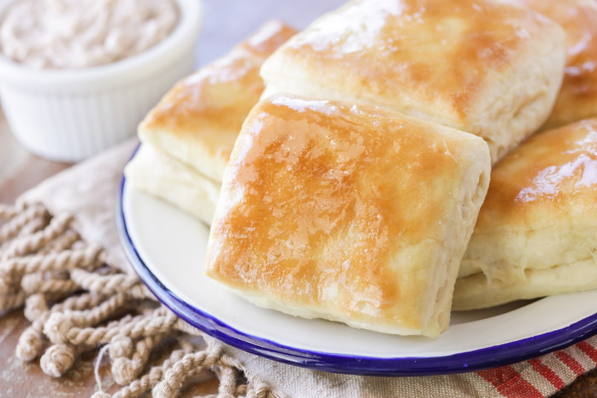 晚餐面包卷和饼干——模仿德州公路旅馆的面包卷堆在白色盘子上，上面有肉桂黄油。
