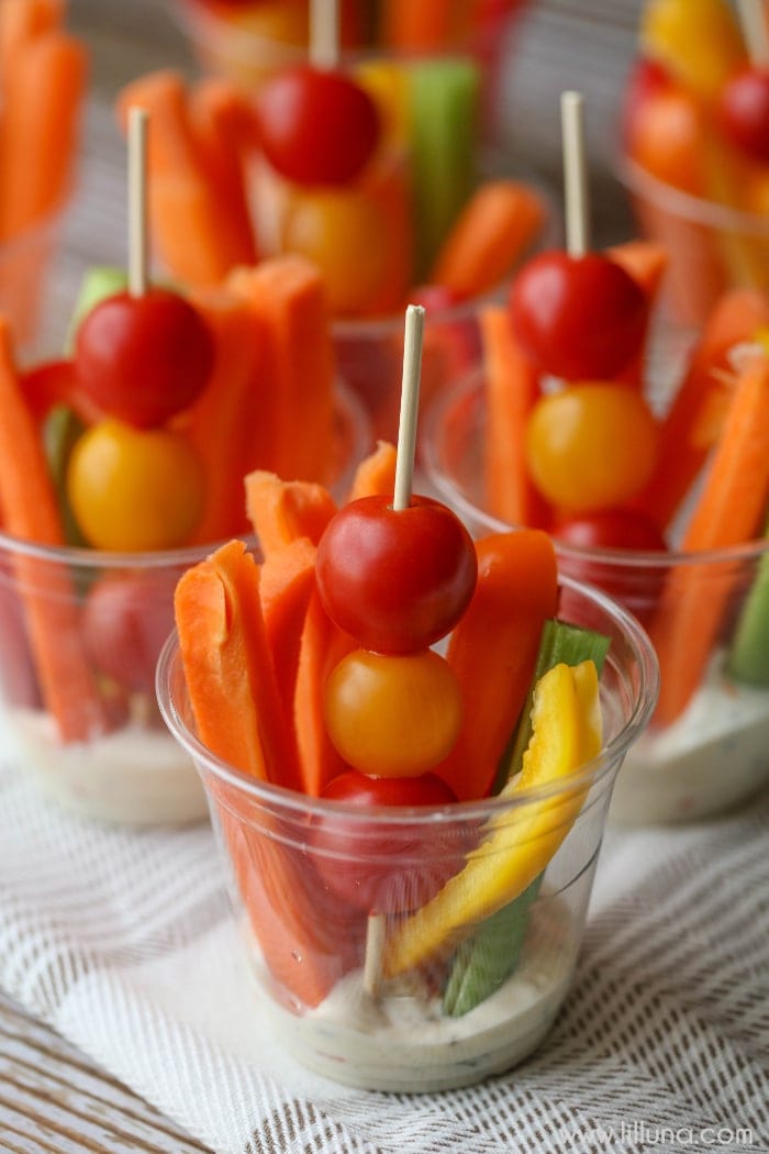 健康的开胃菜——蔬菜装在透明的杯子里，杯底放牧场沙拉酱。