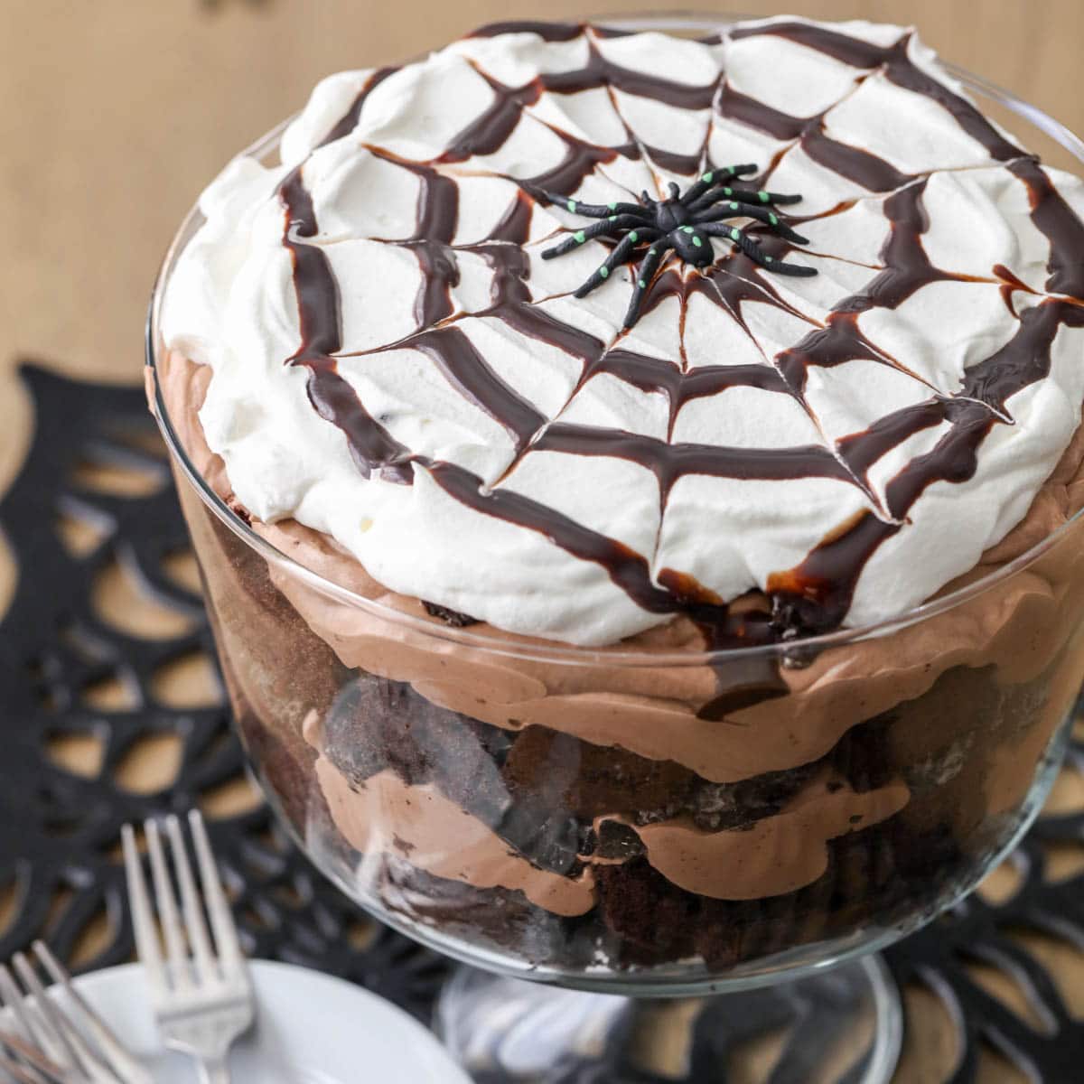 万圣节晚餐创意——巧克力蜘蛛松糕，上面放一个巧克力网和塑料蜘蛛。
