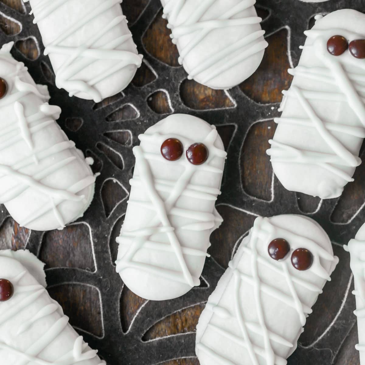 万圣节零食——近距离的木乃伊饼干，上面有棕色的糖果眼睛。