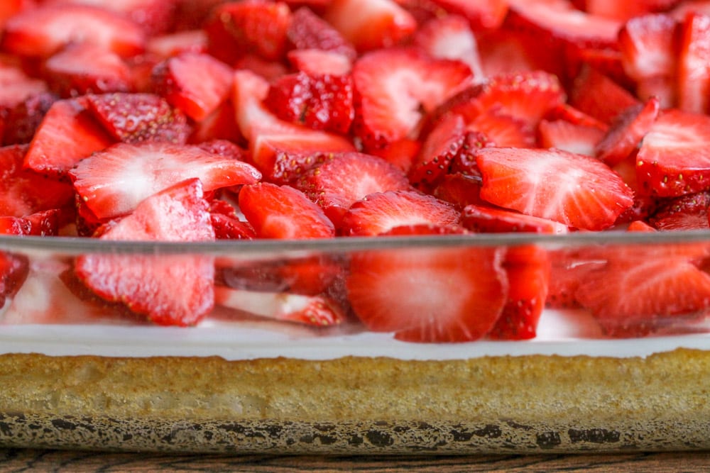 草莓酥饼甜点条在玻璃烤盘中，上面有新鲜的草莓片。