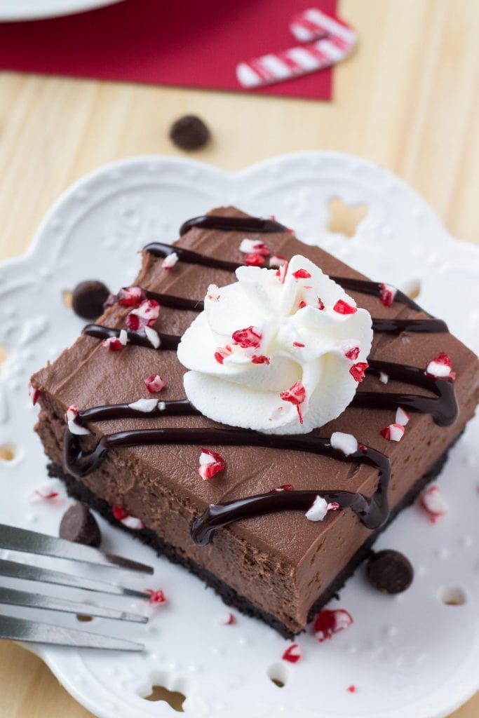 将一块未烘烤的巧克力芝士蛋糕和压碎的拐杖糖放在盘子上