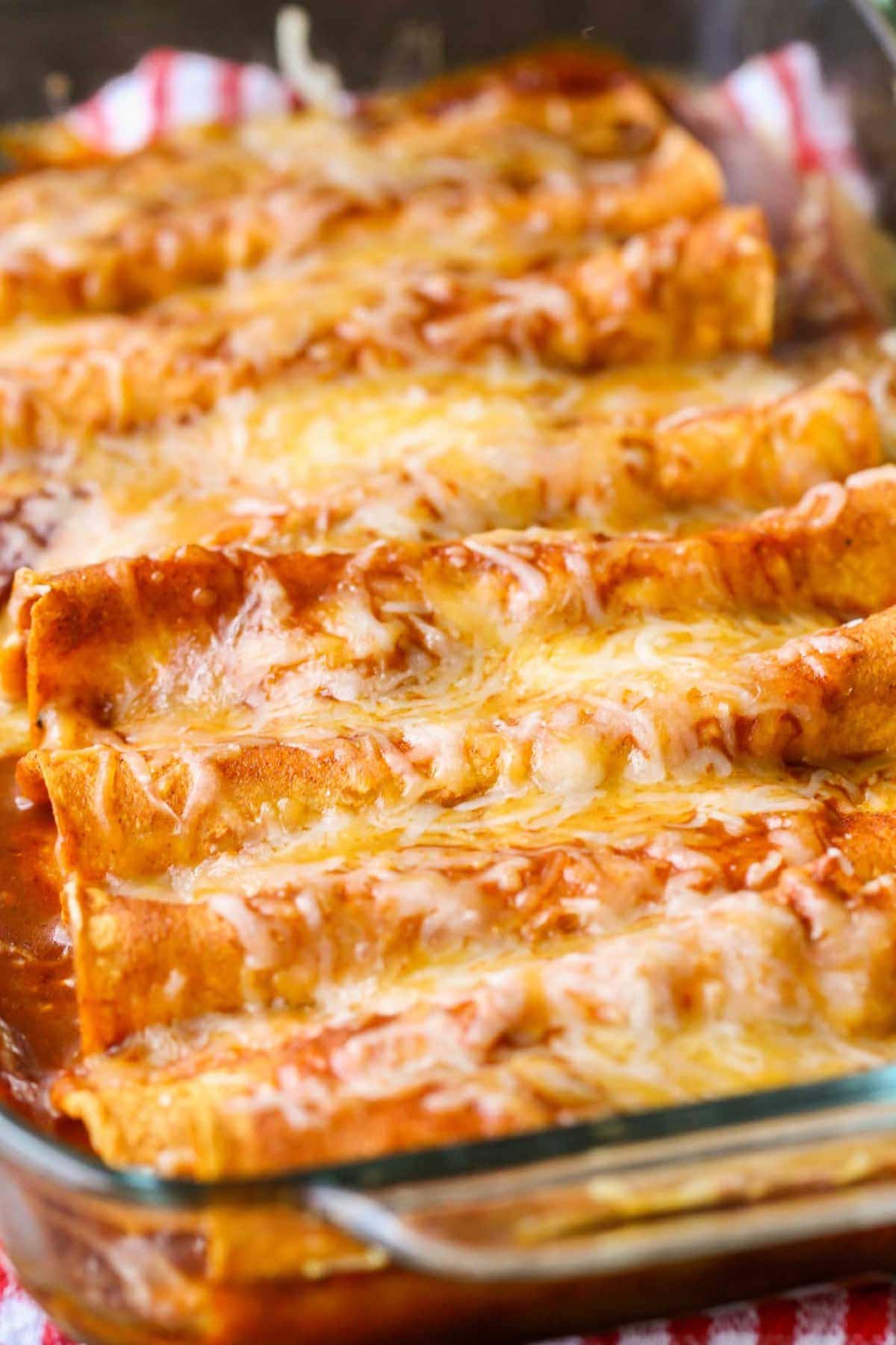 Cheese Enchiladas topped with red sauce and cheese in a glass baking dish