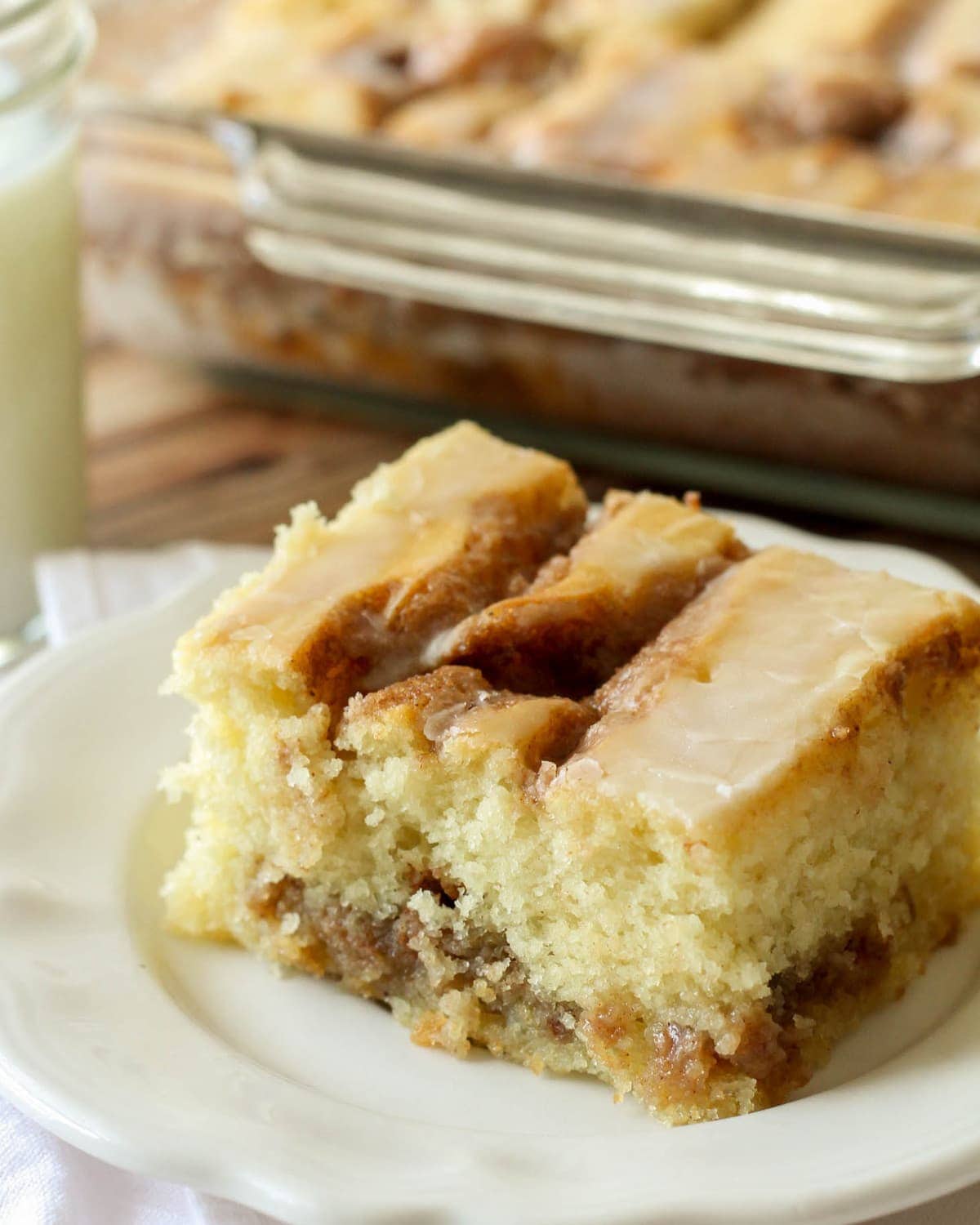 Cinnamon roll cake slice served on a white plate.