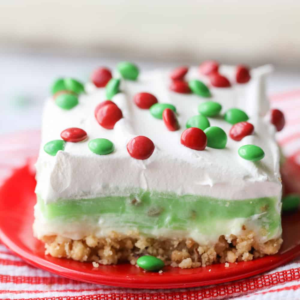 意大利圣诞晚餐创意——一块方形的开心果甜点，上面点缀着红色和绿色的糖果。