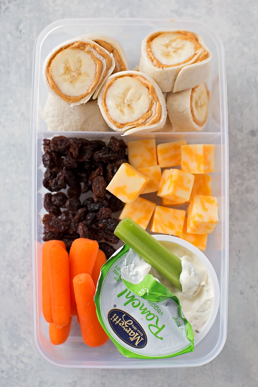 健康的午餐盒，有花生酱香蕉，奶酪，葡萄干和胡萝卜