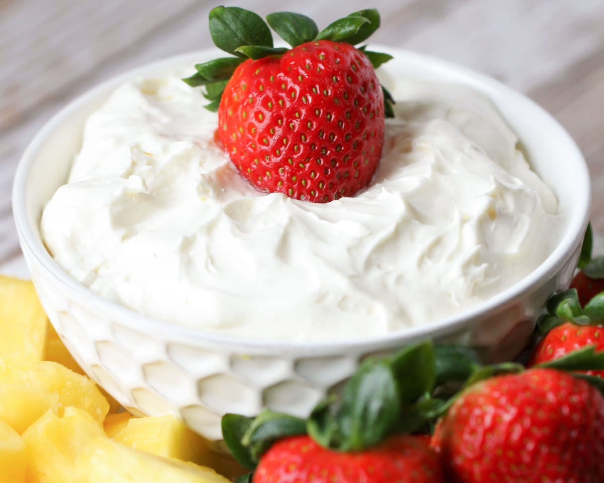 简单的开胃菜-奶油奶酪水果蘸酱顶部草莓在一个白色的碗。
