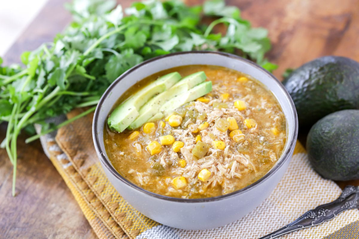 墨西哥汤食谱——一碗绿辣椒bob综合手机客户鸡汤，上面放着牛油果片。