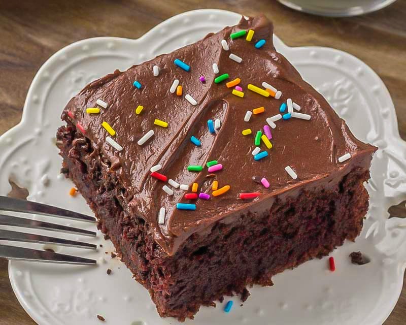 简单的蛋糕食谱——在bob综合手机客户白色盘子上放一片酸奶油巧克力蛋糕，上面撒上彩虹糖。