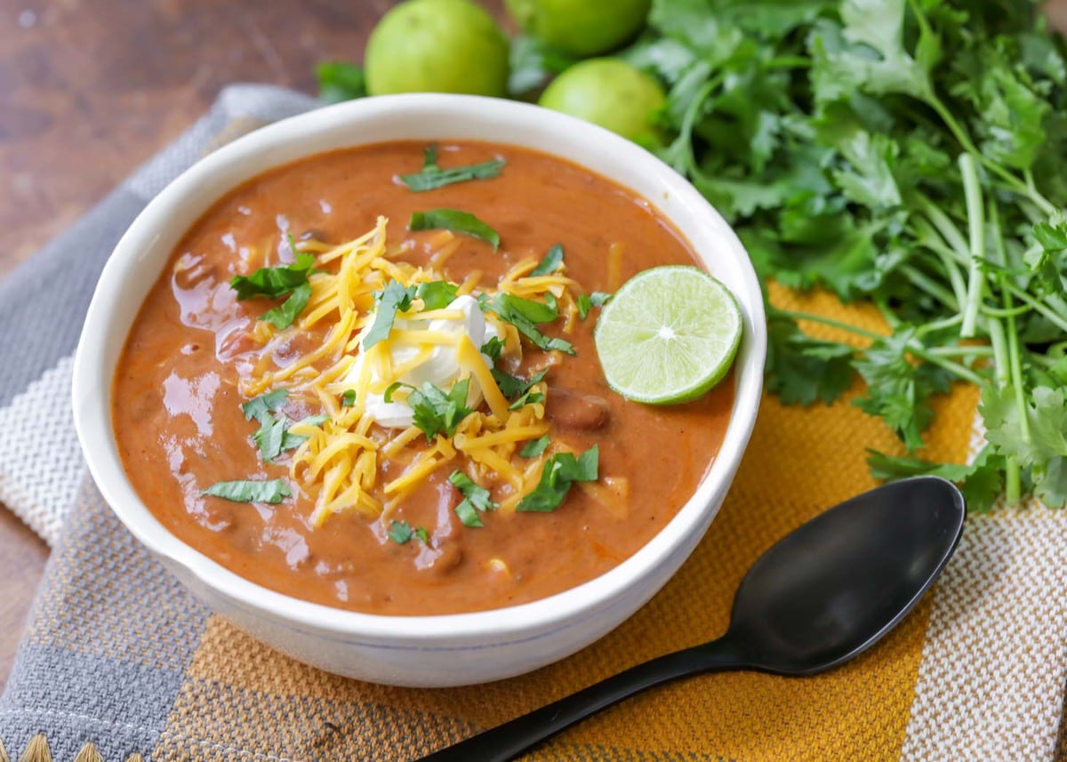 简单的汤食谱——白碗bob综合手机客户炖墨西哥玉米卷汤，上面加酸奶油和奶酪丝。