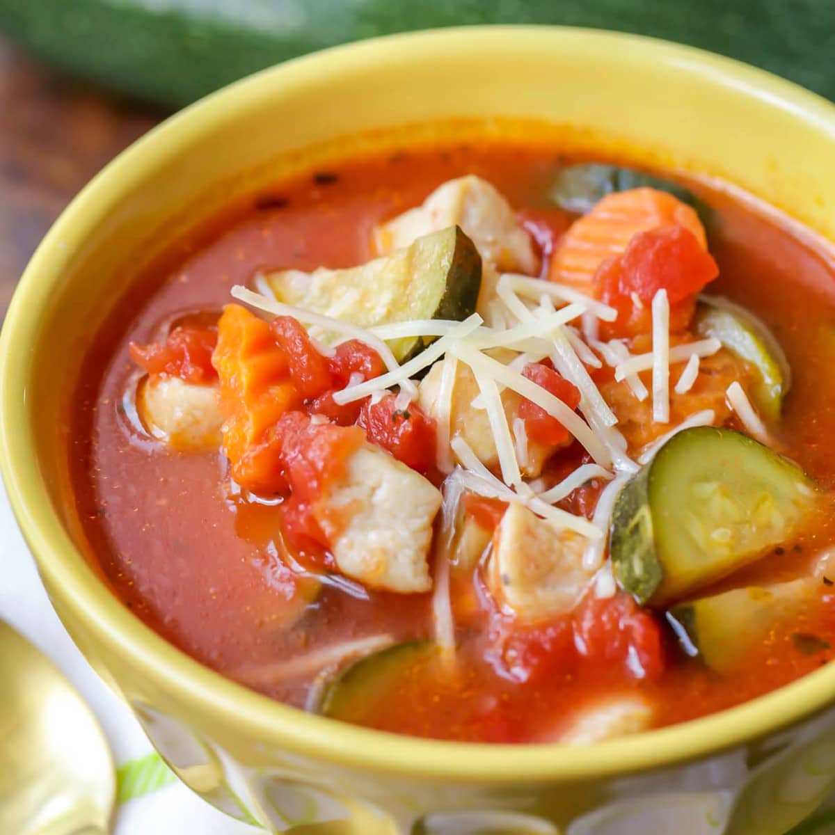 健康的汤食谱——意大利鸡肉bob综合手机客户和蔬菜汤在一个黄色的碗里。