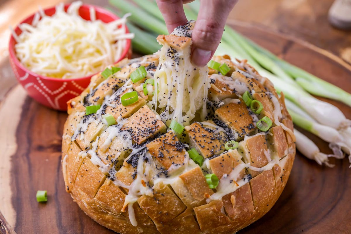超级碗开胃菜——在切菜板上撒上罂粟籽和葱花的面包。