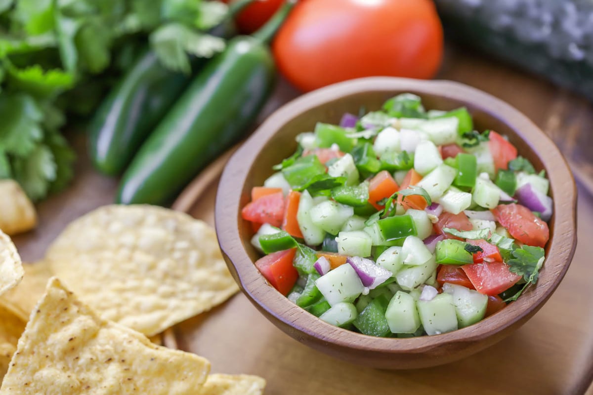Cucumber salsa served in a wooden bowl.
