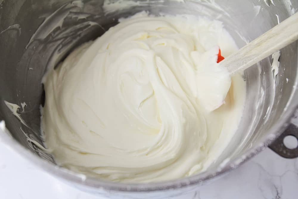 胡萝卜蛋糕的奶油奶酪糖霜在搅拌碗中搅拌。