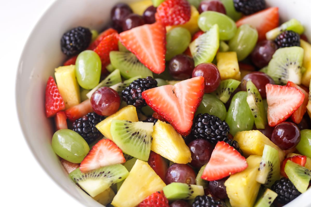 7月4日的配菜——简单的水果沙拉，由浆果、菠萝、猕猴桃和葡萄制成。