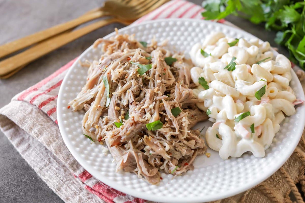 7月4日食谱-慢炖kalbob综合手机客户ua猪肉配通心粉沙拉，放在白色盘子上。