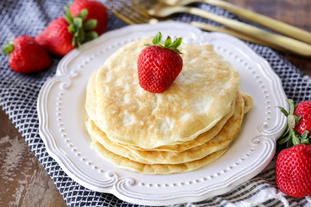 早餐晚餐-堆叠蛋白煎饼上面有草莓。