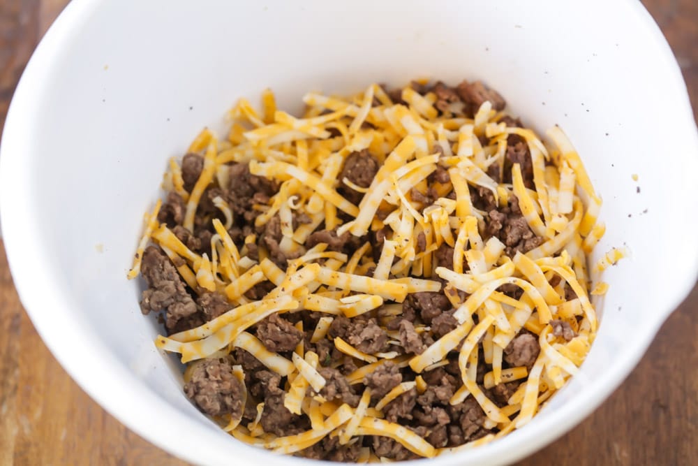 Hamburger meat and cheese in bowl for filling ground beef tacos.