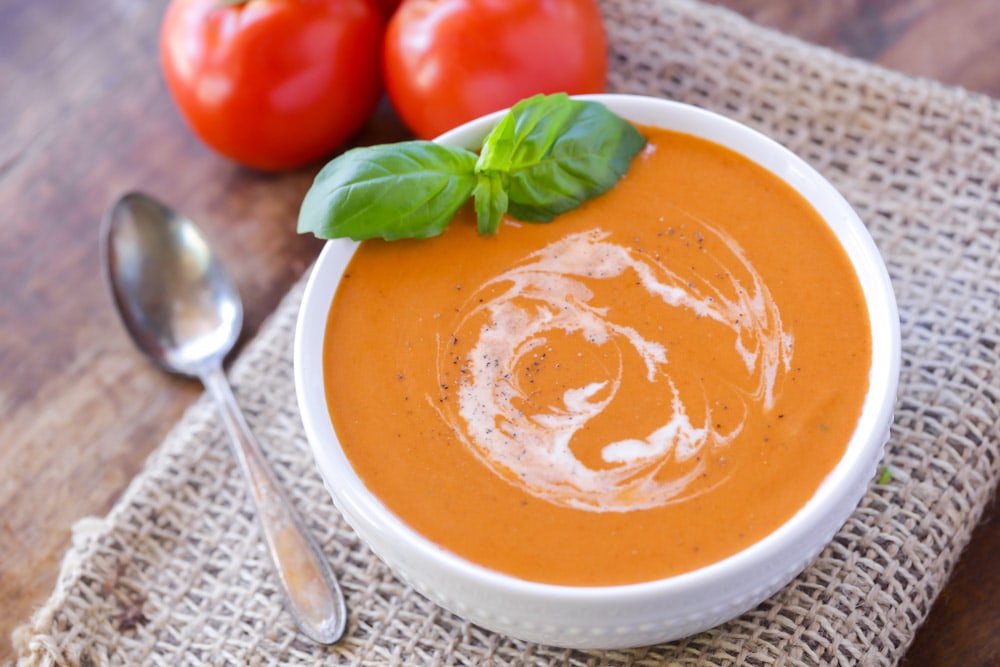 最简单的汤食谱-番茄浓汤在白色bob综合手机客户碗顶部与新鲜罗勒。