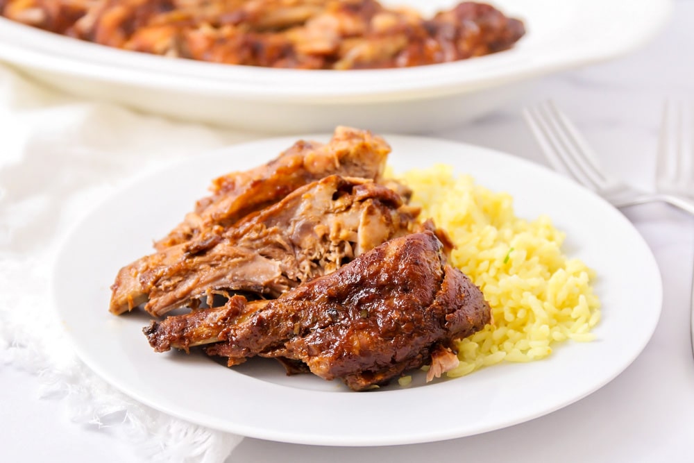 家庭晚餐建议——慢炖猪排放在白色盘子里，配上米饭。