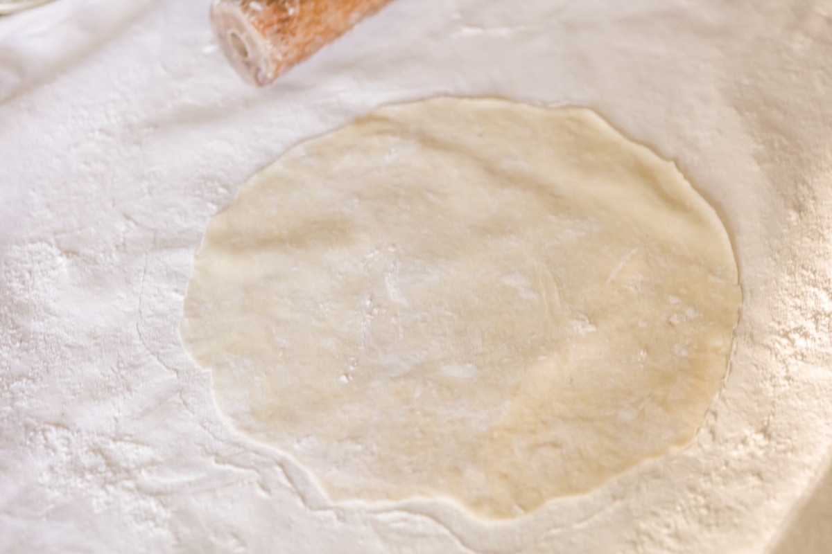 把肉馅卷饼面团铺在撒了面粉的表面