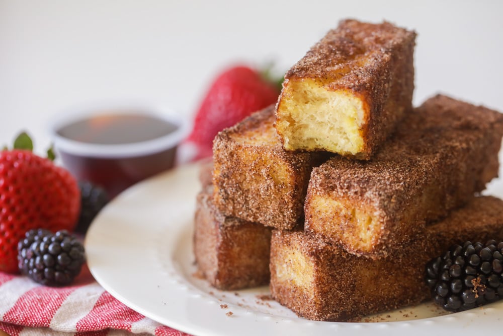Easy Breakfast Ideas - a stack of French toast sticks on a white plate.