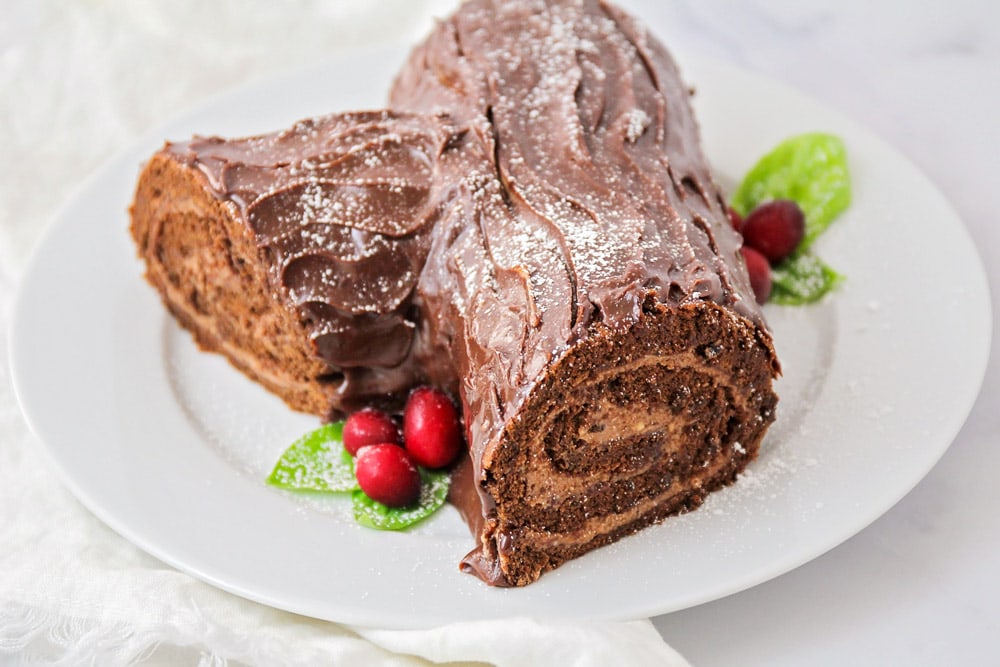 巧克力蛋糕食谱-圣诞原木蛋糕上bob综合手机客户的白色浅盘。