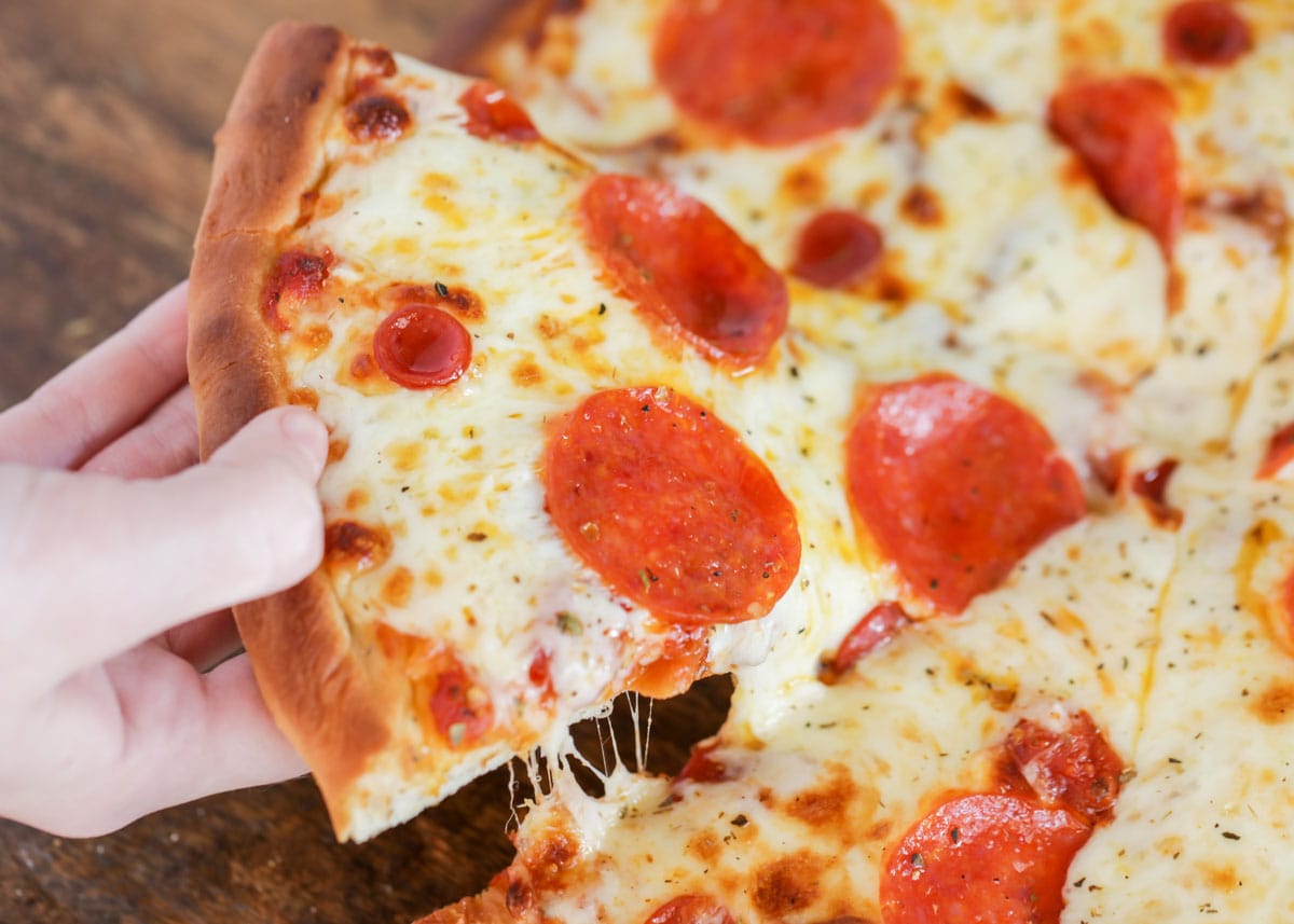 超级碗开胃菜-在木砧板上的意大利辣香肠披萨。