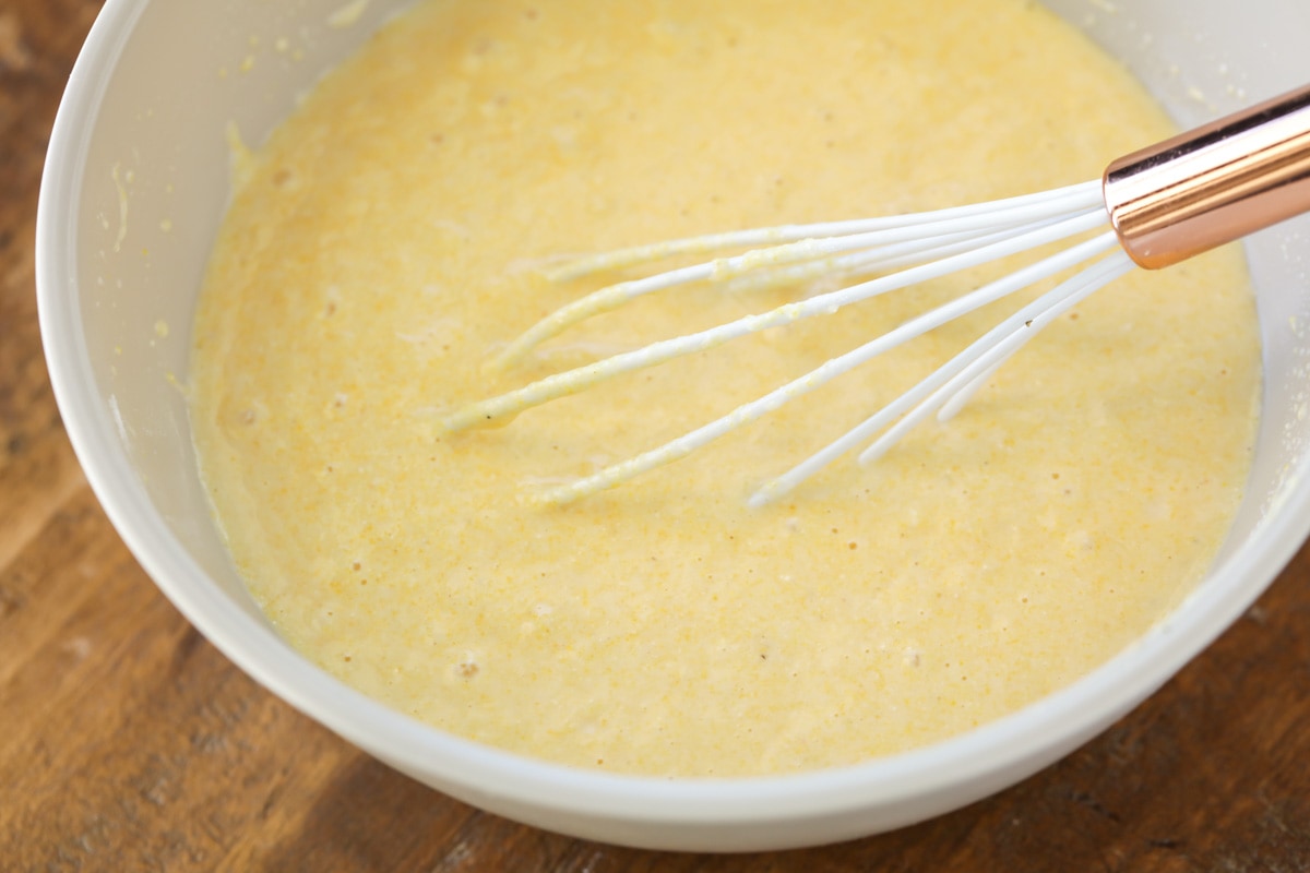 用打蛋器将甜玉米面包松饼面糊放入白碗中。