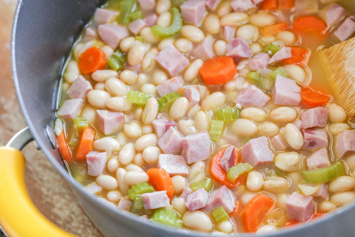 把火腿、豆子、胡萝卜和芹菜放在锅里煮熟