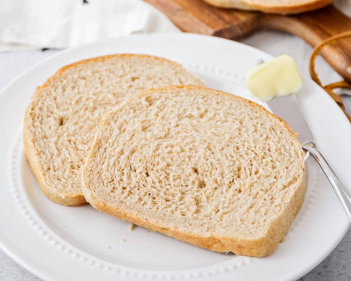 酵母面包食谱——在盘子里bob综合手机客户放两片小麦面包和一小块黄油。