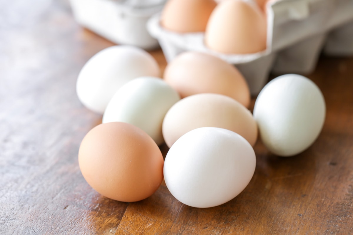 棕色和白色的鸡蛋放在木桌上。
