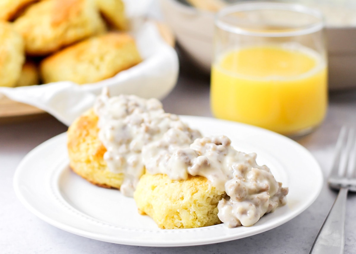 Easy Breakfast Ideas - biscuits topped with a sausage gravy on a white plate.