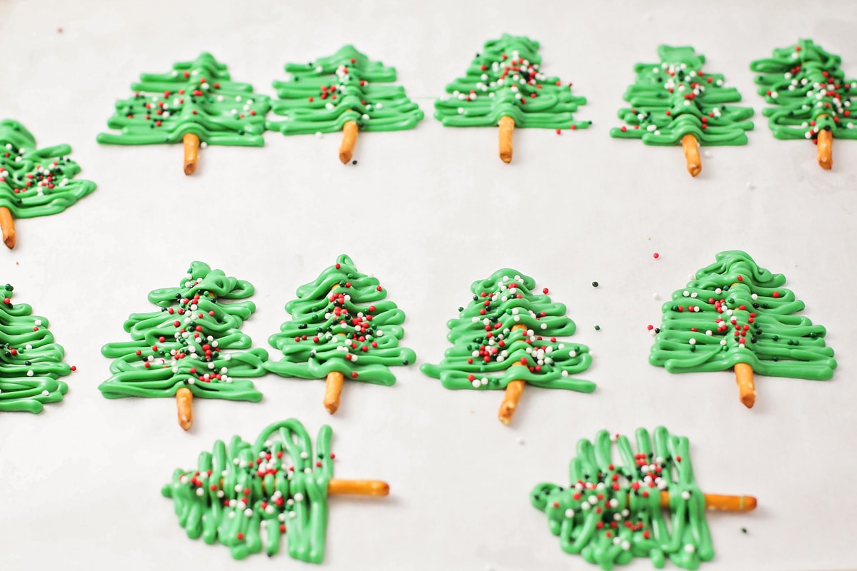 糖果融化树在羊皮纸衬里的烤盘上做圣诞纸杯蛋糕。