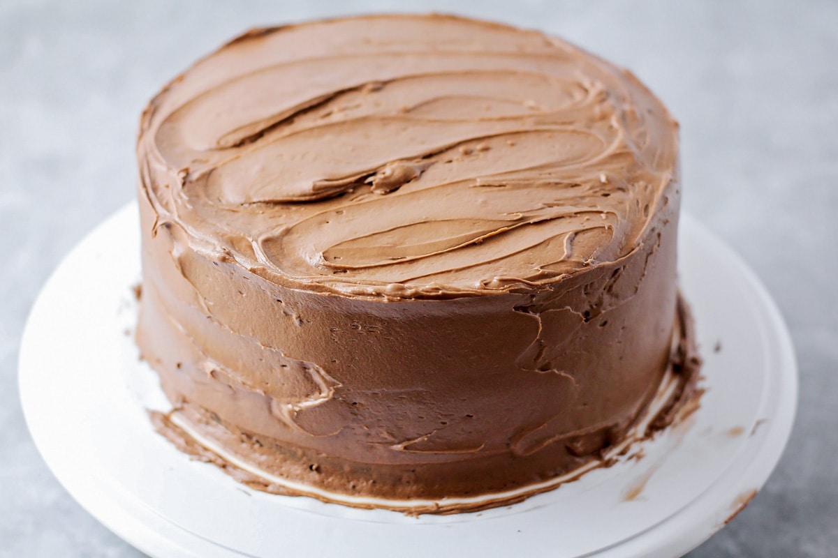 巧克力奶油糖霜洒在蛋糕上。