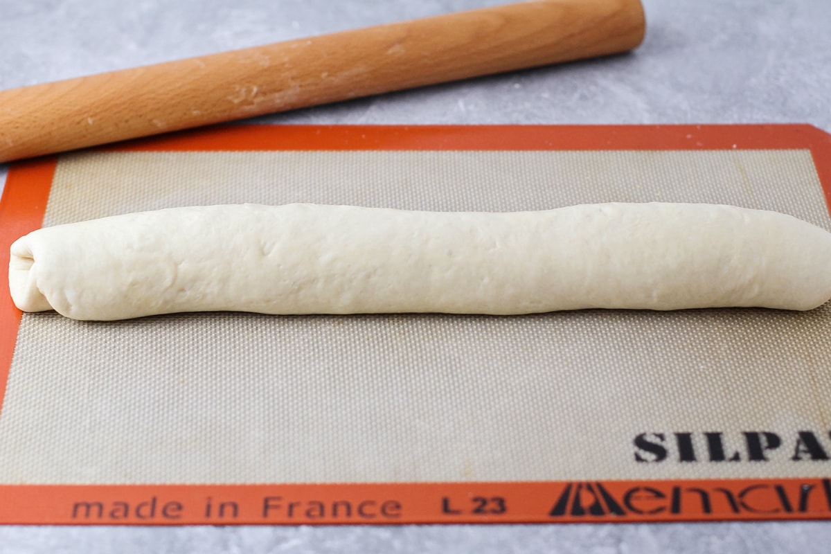 在滑垫上滚动的法国面包面团。