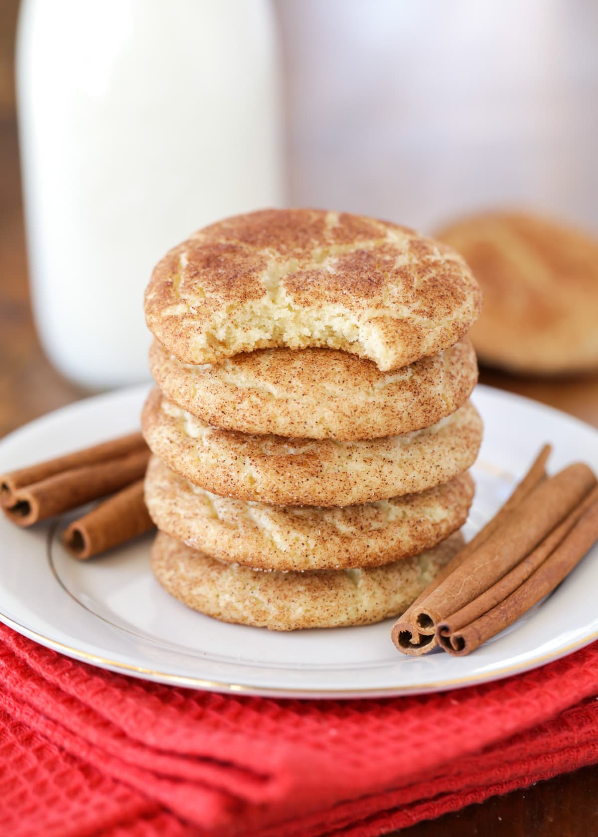 A stack of snickerdoodle cookies with the top one missing a bite.