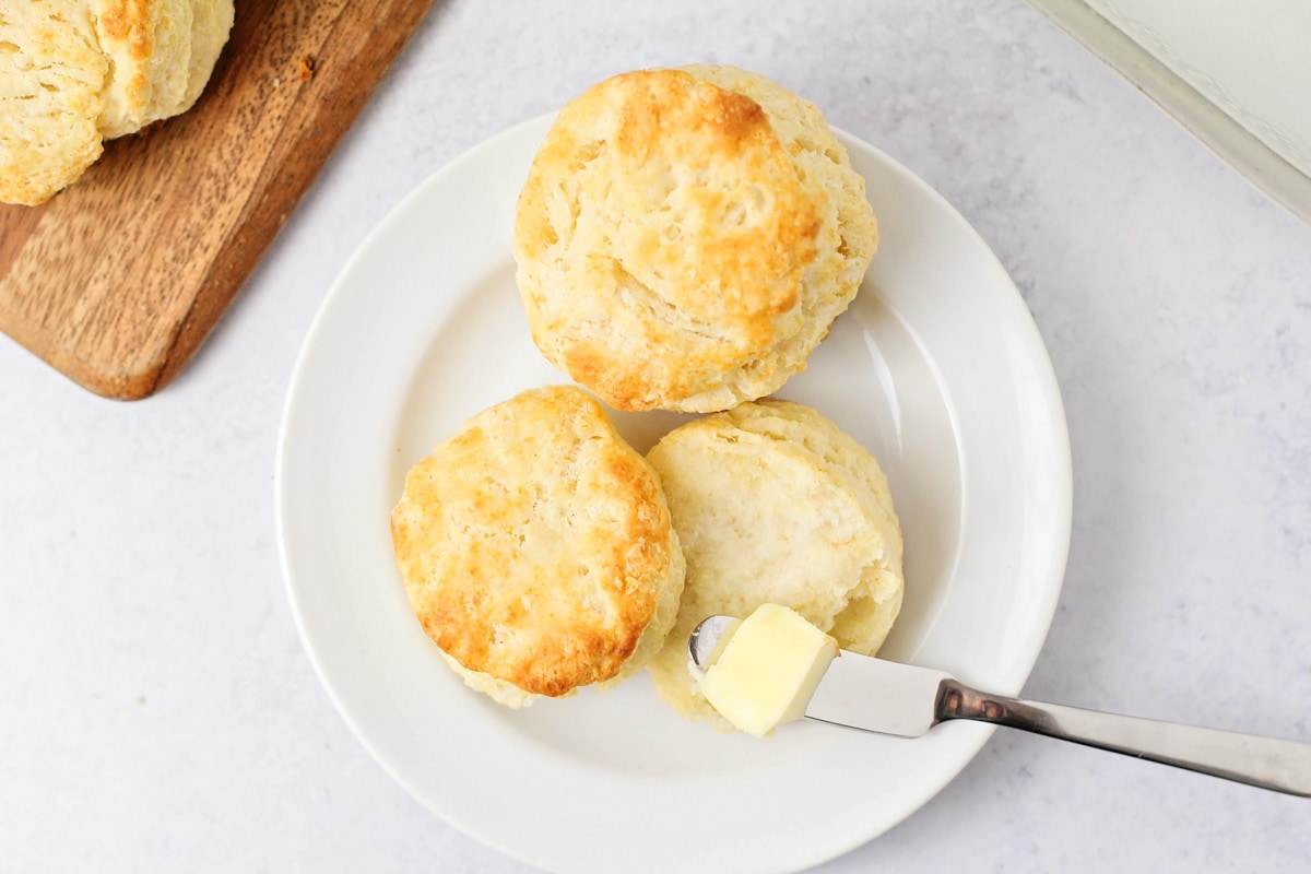 两块简单的饼干，上面涂着黄油，放在白盘子里。