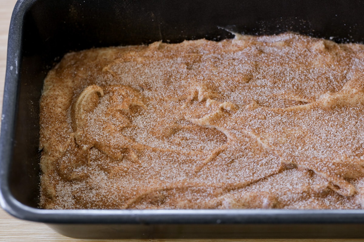把士力鸡面糊放在平底锅里，撒上肉桂糖混合物。