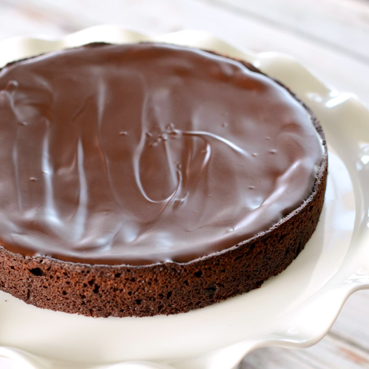 简单的无面粉巧克力蛋糕食谱在白色蛋糕架。bob综合手机客户