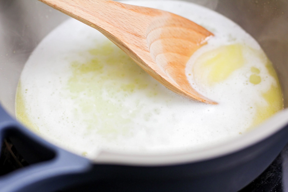 在平底锅中搅拌融化的原料，准备奶油泡芙蛋糕。